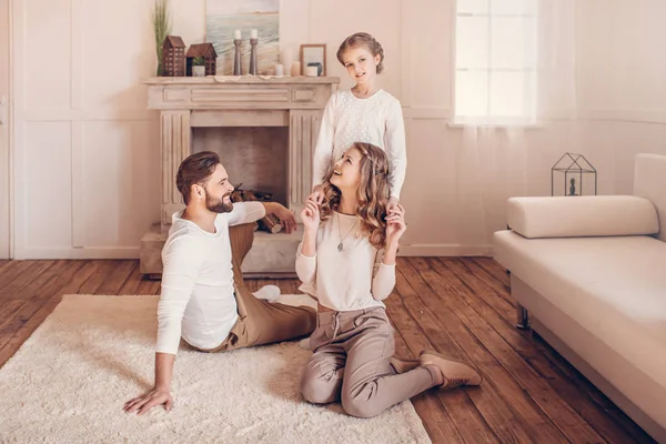 Familia joven y feliz con un niño pasando tiempo juntos en casa - foto de stock