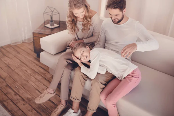 Blick aus der Vogelperspektive auf eine glückliche Familie mit einem Kind, das die Zeit zu Hause auf dem Sofa verbringt — Stockfoto
