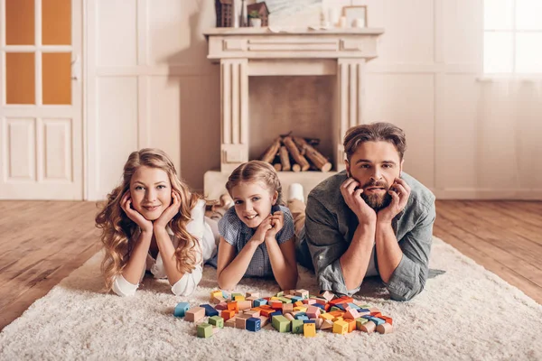 Glückliche Familie spielt mit Bauarbeiter und liegt zu Hause auf dem Boden — Stockfoto