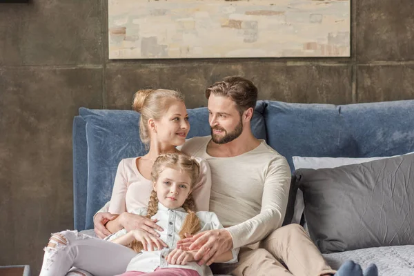 Glückliche Mutter, Vater und Tochter umarmen und lächeln zu Hause — Stockfoto