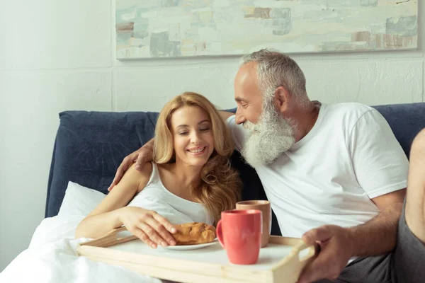 Parejas maduras con desayuno en la cama - foto de stock