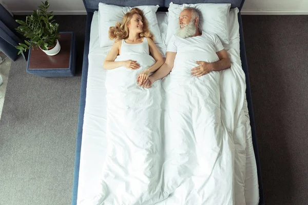 Pareja acostada en la cama - foto de stock