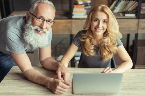 Pareja de mediana edad trabajando juntos en el ordenador portátil - foto de stock