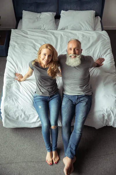 Couple d'âge moyen assis sur le lit — Photo de stock