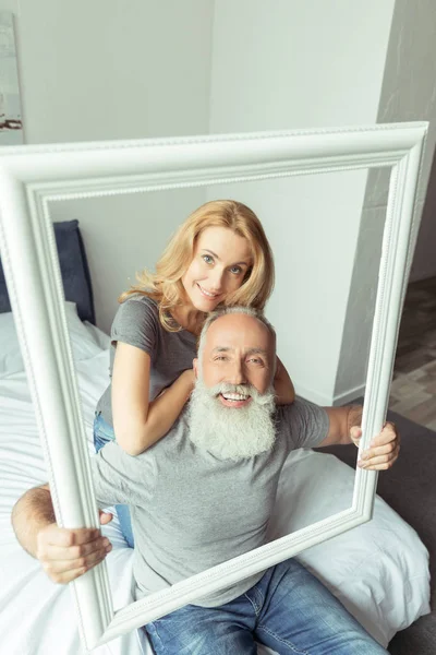 Middle aged couple with white frame — Stock Photo