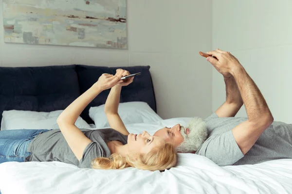 Пара среднего возраста, лежащая в постели — стоковое фото