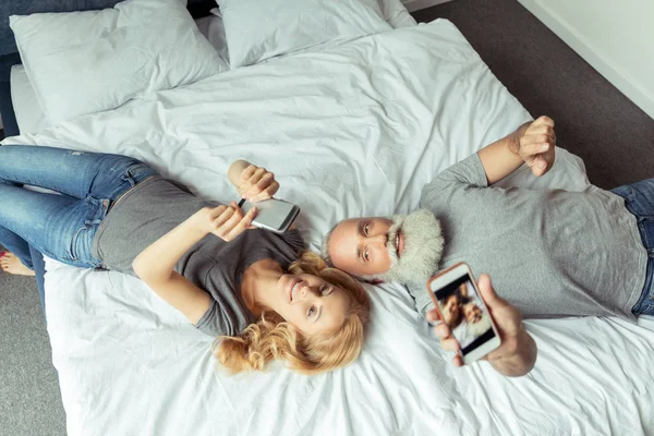 Couple d'âge moyen couché au lit — Photo de stock