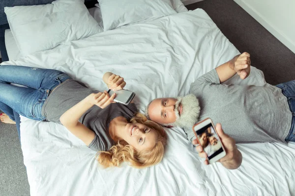 Pareja de mediana edad acostada en la cama - foto de stock