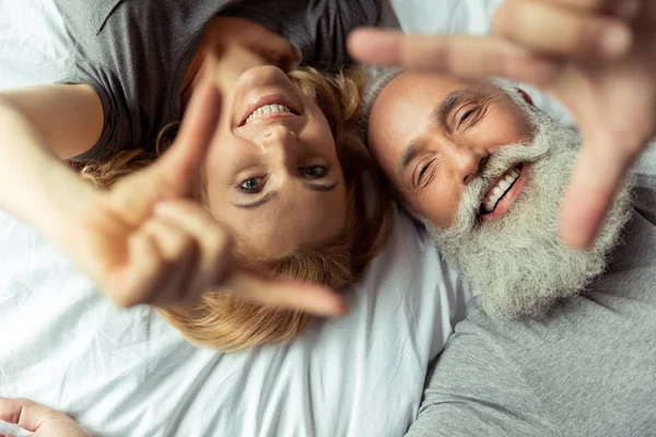 Pareja de mediana edad acostada en la cama - foto de stock