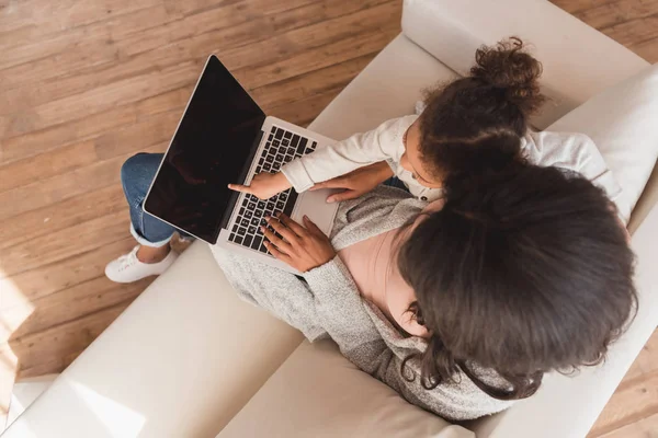 Mother and daughter using laptop — Stock Photo