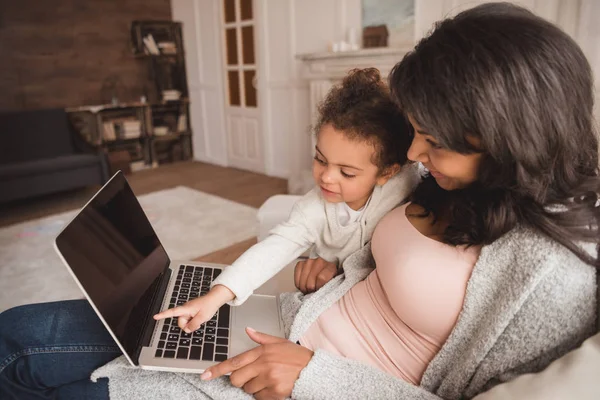 Madre e hija usando laptop - foto de stock