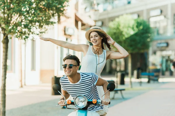 Pareja joven montando scooter - foto de stock