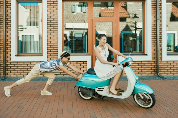 Mujer montando scooter retro - foto de stock