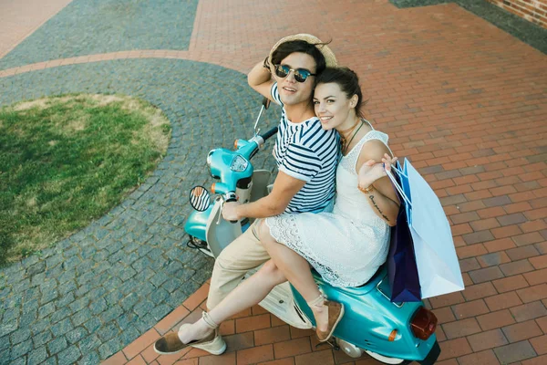 Joven sonriente pareja cabalgando en scooter - foto de stock
