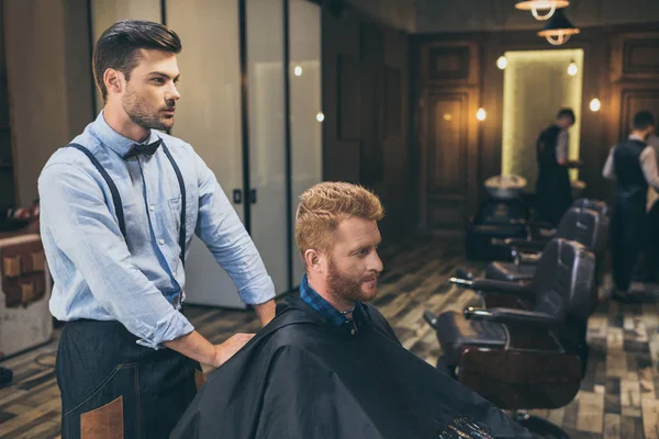 Barber with customer in barber shop — Stock Photo