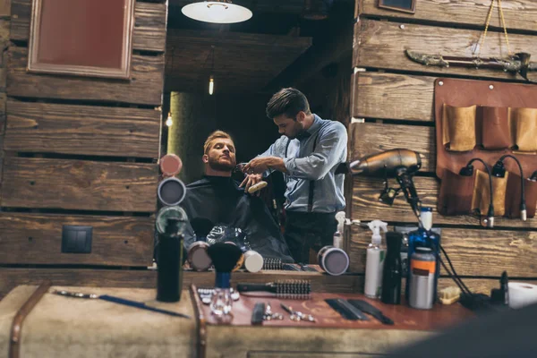 Barber trimming customers beard — Stock Photo
