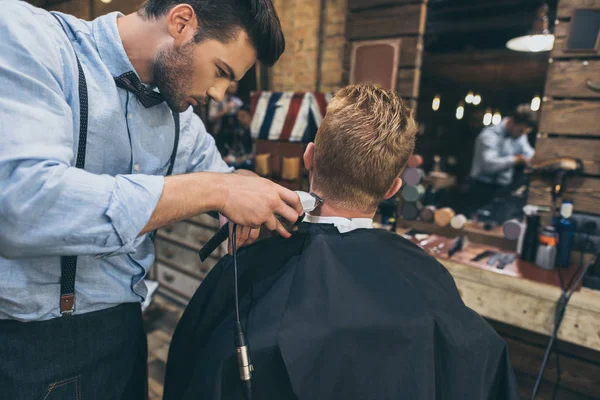 Barbier coupe les cheveux du client — Photo de stock