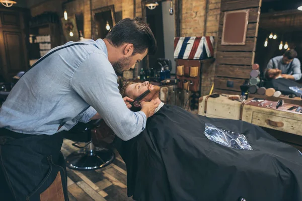 Barbero peinando barba clientes - foto de stock