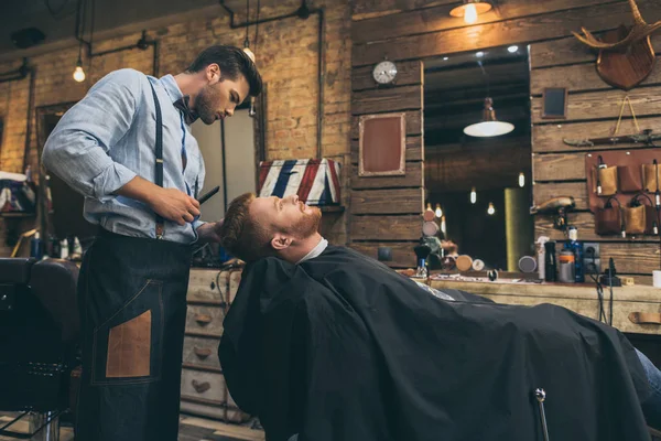 Barbier coupe les cheveux du client — Photo de stock