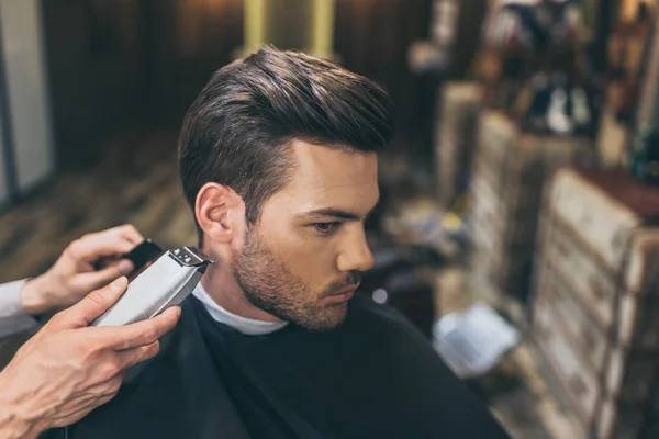 Barbier coupe les cheveux du client — Photo de stock