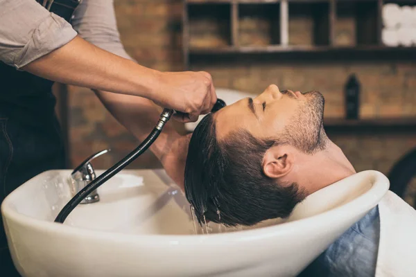 Hairstylist washing clients hair — Stock Photo