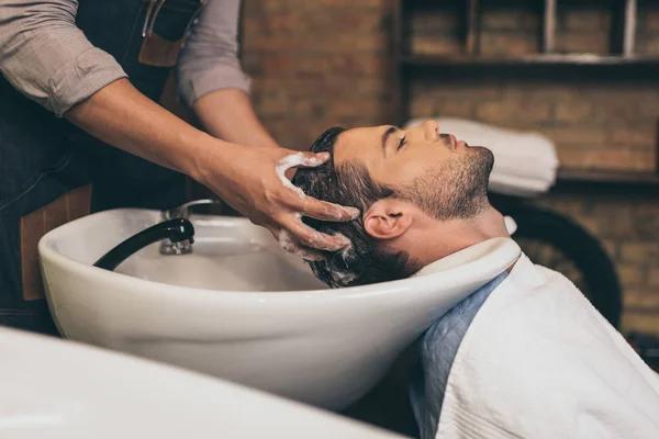 Перукар миття волосся клієнтів — стокове фото