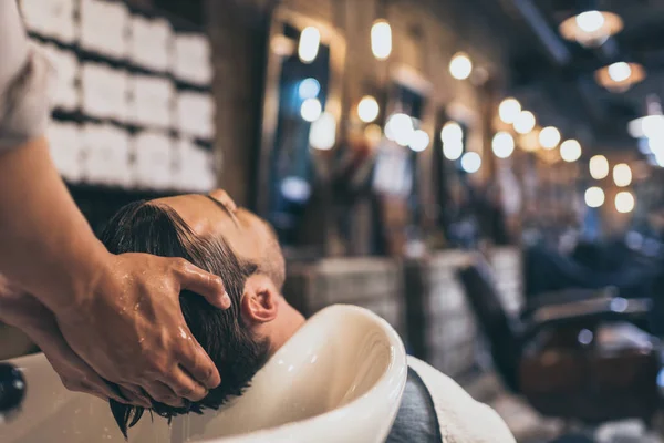 Hairstylist washing clients hair — Stock Photo