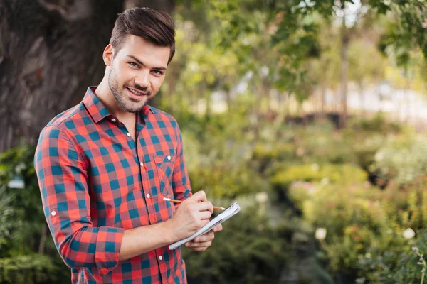 Gardener with notebook in hands — Stock Photo