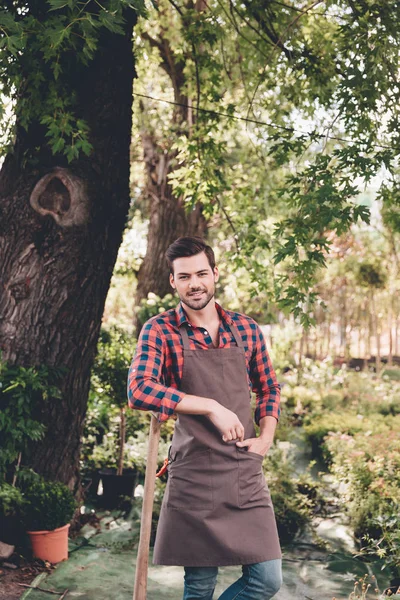 Jovem jardineiro sorridente em avental — Fotografia de Stock