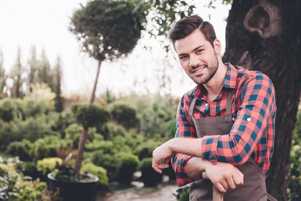 Giovane giardiniere sorridente in grembiule — Foto stock