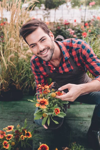Jardinier avec pot de fleurs dans les mains — Photo de stock