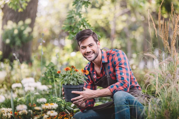 Jardinier avec pot de fleurs dans les mains — Photo de stock