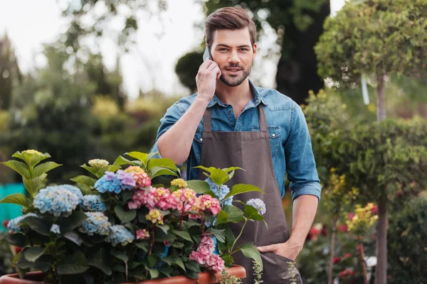 Giardiniere con smartphone in giardino — Foto stock