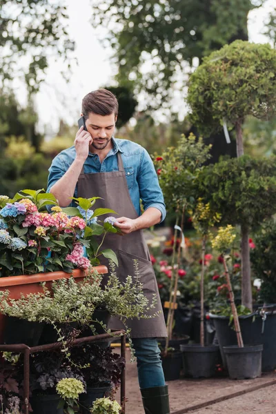 Jardinero con smartphone en jardín - foto de stock