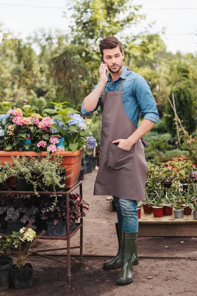 Giardiniere con smartphone in giardino — Foto stock