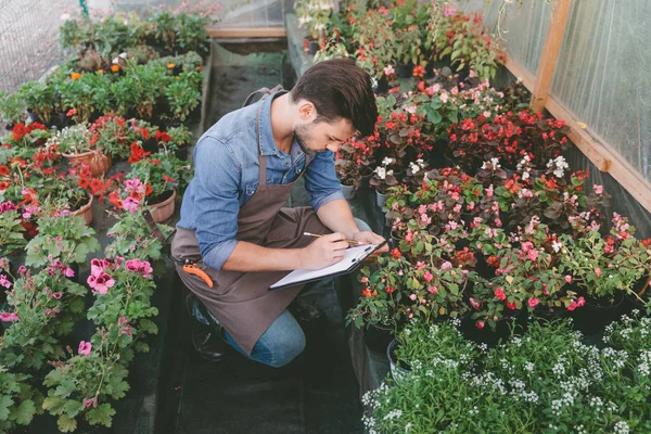 Giardiniere prendere appunti durante il lavoro — Foto stock