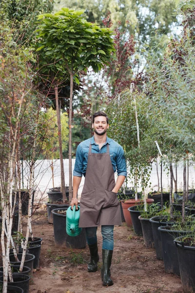 Gardener with watering can in hand — Stock Photo