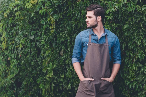 Thoughtful gardener in apron — Stock Photo