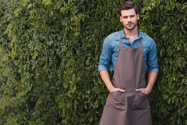 Thoughtful gardener in apron — Stock Photo