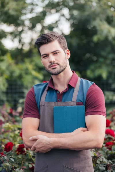 Giardiniere con tavoletta digitale in giardino — Foto stock