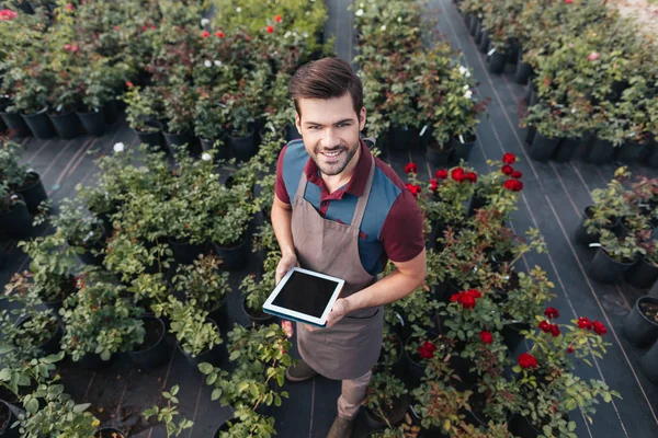 Jardinero con tableta durante el trabajo en el jardín - foto de stock