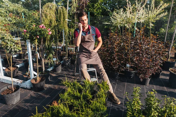 Giardiniere con smartphone in giardino — Foto stock