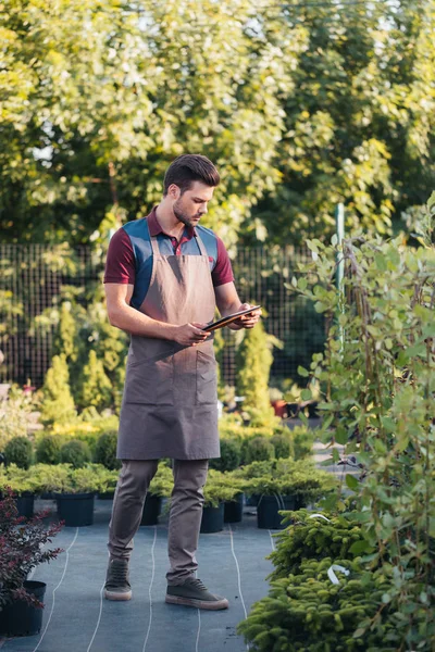 Jardinier avec tablette pendant le travail dans le jardin — Photo de stock