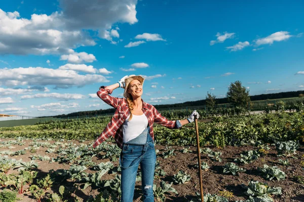 Agricultor con azada que trabaja en el campo - foto de stock