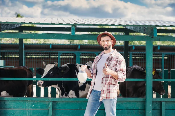 Agricultor con leche fresca en establo - foto de stock