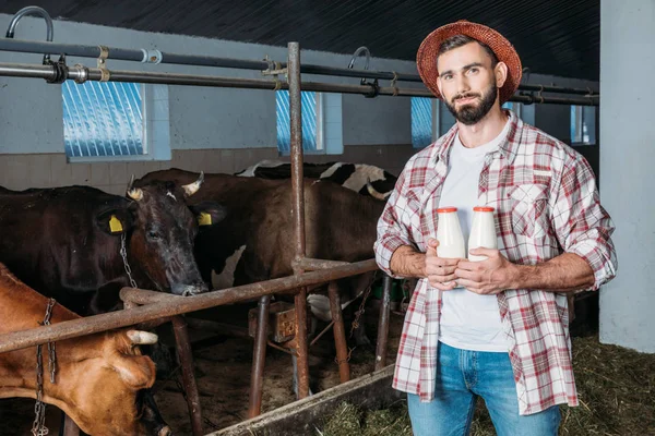 Agricultor com leite fresco em estábulo — Fotografia de Stock