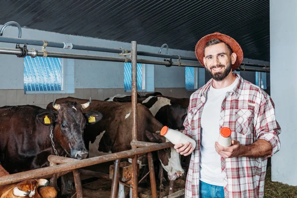 Agricultor com leite fresco em estábulo — Fotografia de Stock