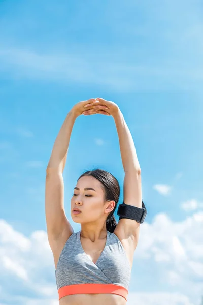 Asian sportswoman stretching — Stock Photo