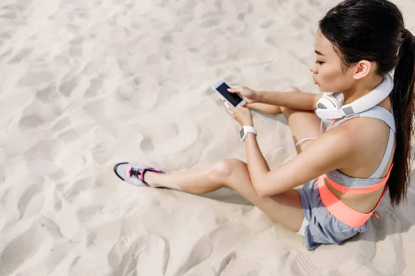 Sportlerin mit Smartphone und Kopfhörer — Stockfoto