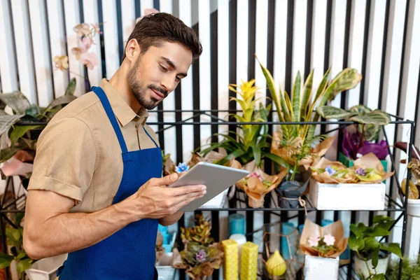 Male florist with digital tablet — Stock Photo